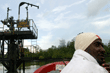 An Ijaw militant drives past a Soku oil well in the Niger Delta, 2004.