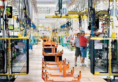 General Motors workers test equipment along the assembly line. KEVIN W. FOWLER/AP 