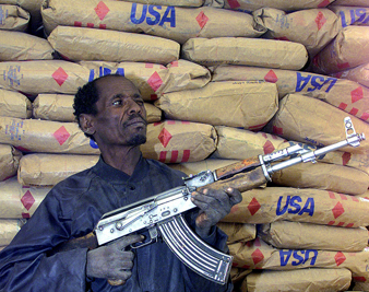 A guard protects flour rations donated by the United States at a feeding center in Wollo, Ethiopia, in 2001. GEORGE MULALA/REUTERS  