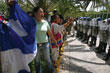 Supporters of ousted President Manuel Zelaya demonstrate in front of police officers outside a meeting between government offic