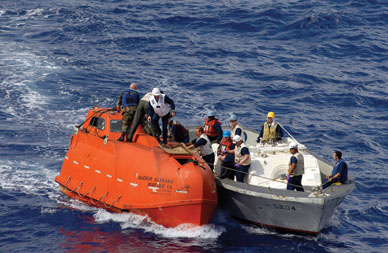 A US Navy team tows the lifeboat where Somali pirates held Capt. Richard Phillips captive. JON RASMUSSEN/AP PHOTO 